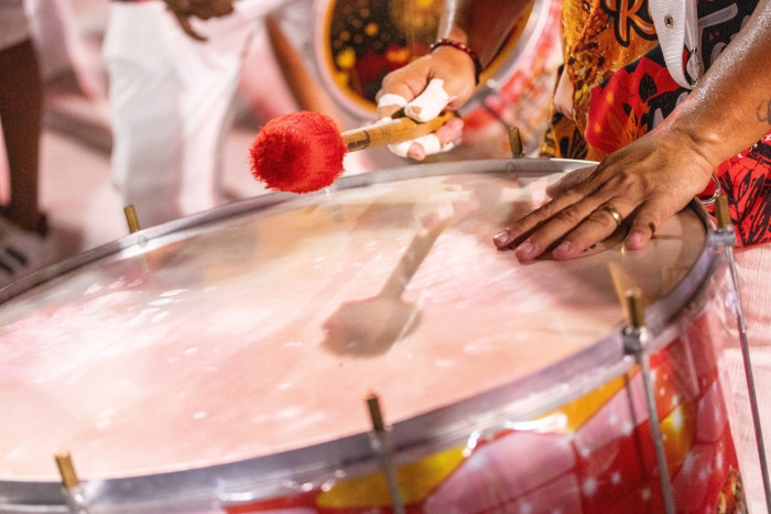 Pessoa tocando tambor, um dos instrumentos do samba.